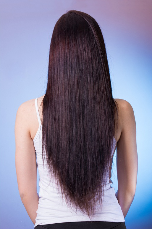 A woman getting her hair straightened at a salon
